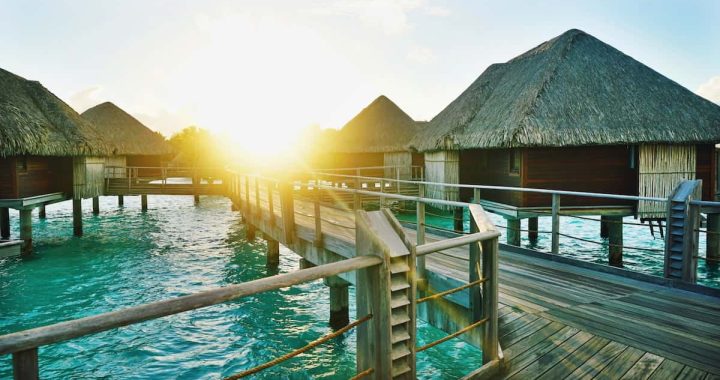 brown wooden dock between houses, overwater bungalow villas in french polynesia